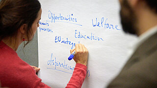 Illustrative image: a project participant drawing on a flip chart